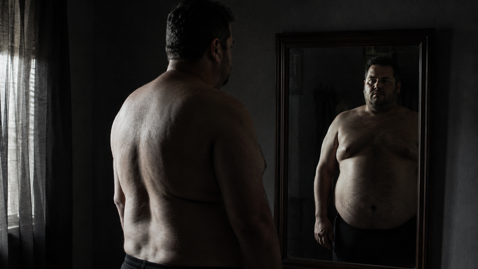 Hombre mirando su reflejo en el espejo